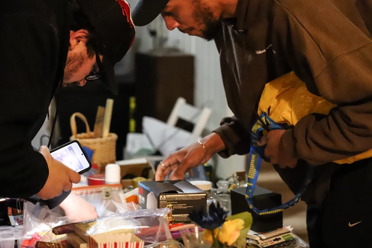 Two men viewing items on table