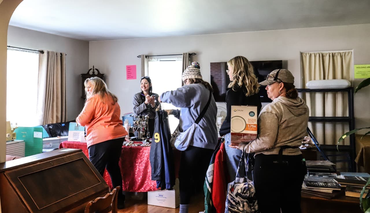 People carrying items to checkout at estate sale